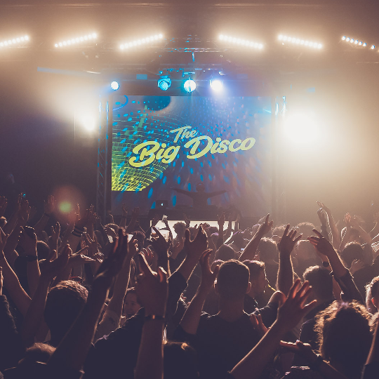 A crowd dancing in front of Komedia's Big Disco stage