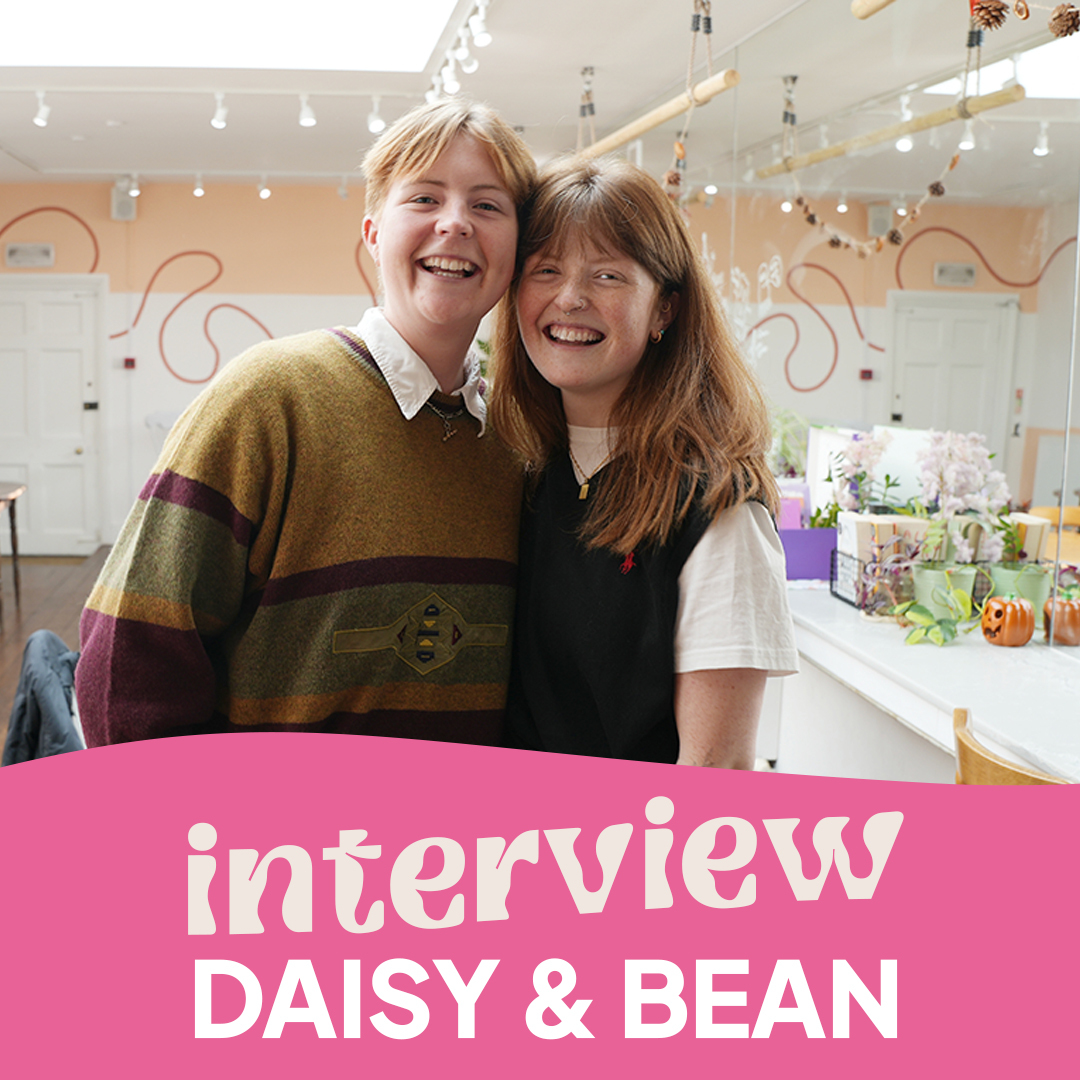 Molly and Emily, co-owners of Daisy and Bean, smiling in the brightly lit interior of the cafe.