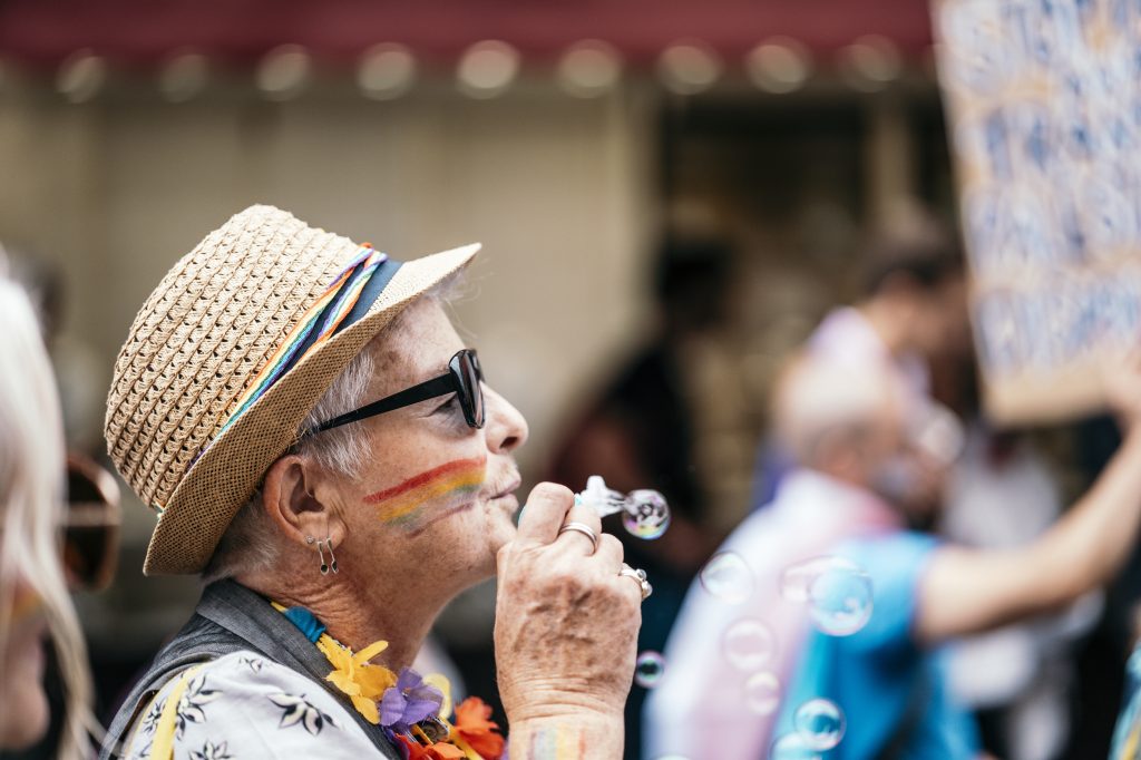 a person blowing bubbles with rainbows on their face