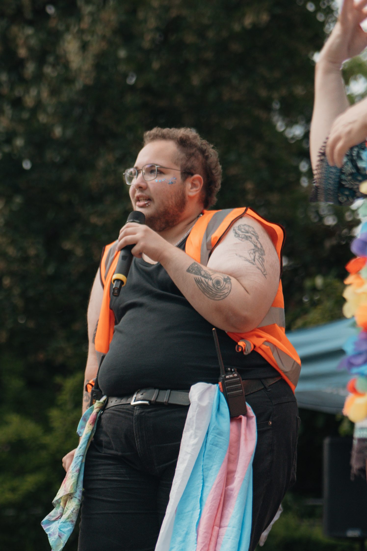 Nathan with a microphone giving the closing speech at Bath Pride 2025