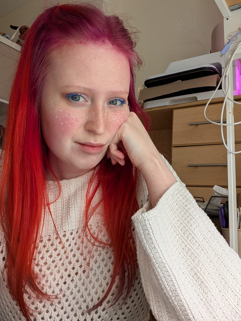 Jojo with colourful red and pink hair and painted freckles