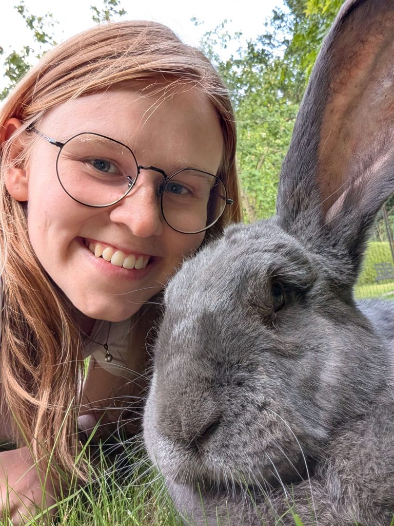 Cato smiling in the grass with massive rabbit Gradje