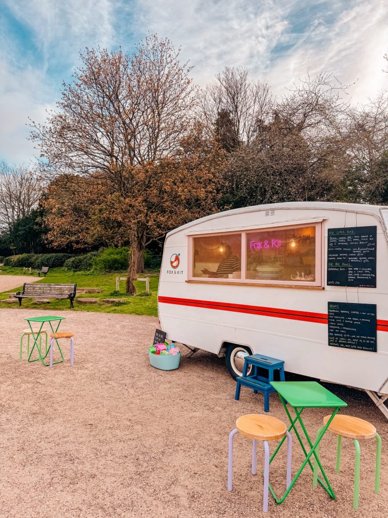 Jean Claude, a vintage caravan, surrounded by picnic tables and a beautiful park