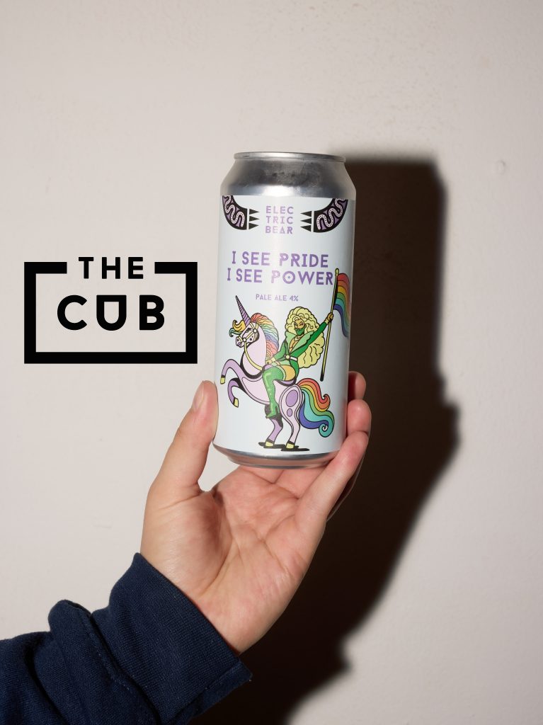 a hand holding Electric Bear's pride pale ale, "I see pride I see power"